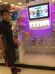 Antonio pointing to an empty display of Amiibos