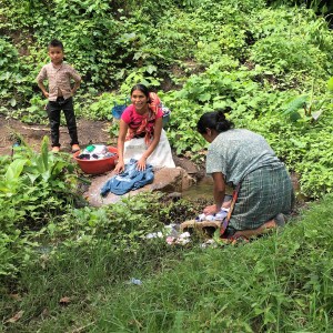 Guatemalan women washing clothes at a creek.